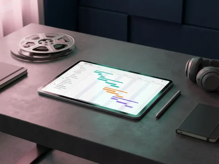 Modernes Tablet mit bunter Projektzeitlinie auf minimalistischem Schreibtisch mit Filmrolle und Kopfhörern