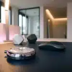 Silberne Stoppuhr auf dunklem Schreibtisch in modernem deutschen Büro mit rosa Akzentbeleuchtung
