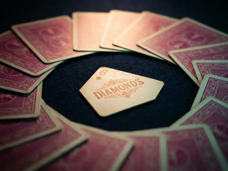 Einzelne Spielkarte mit Fibonacci-Zahl, umgeben von fächerförmig angeordneten verdeckten Karten mit rosa-magentafarbenen Rückseiten auf dunkelblauem Untergrund.
